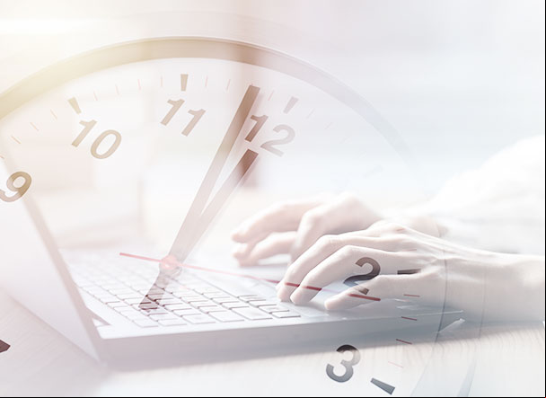 Cut-out image of hands typing on a computer. And above the image is the transparency of a clock.
