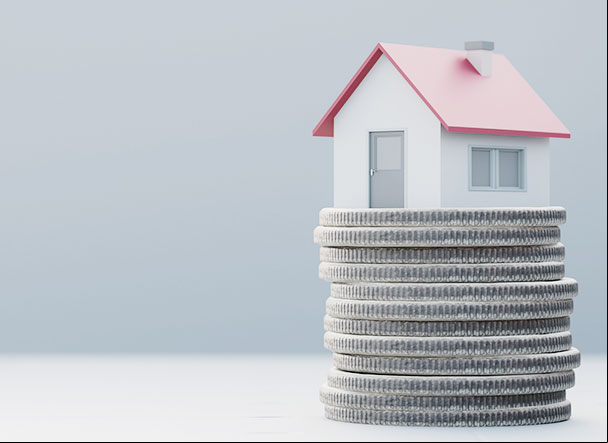 casa de madeira em miniatura em cima de moedas