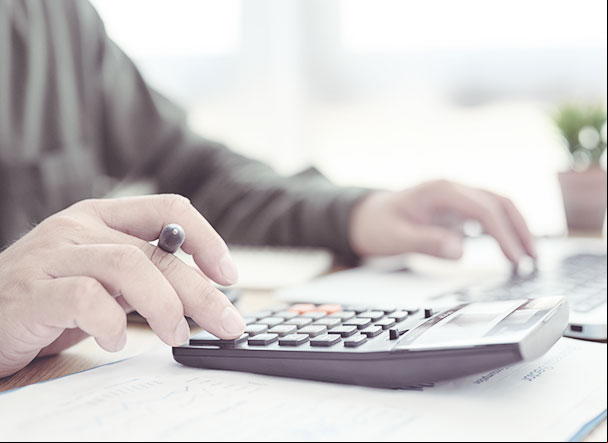 Pessoa utilizando calculadora preta com teclas em preto e vermelho