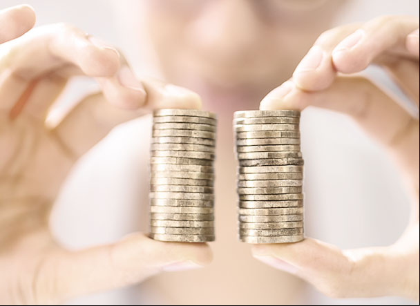 Person holding two equal stacks of gold coins